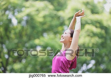 Stock Photography - Young Japanese girl stretching in the park. Fotosearch