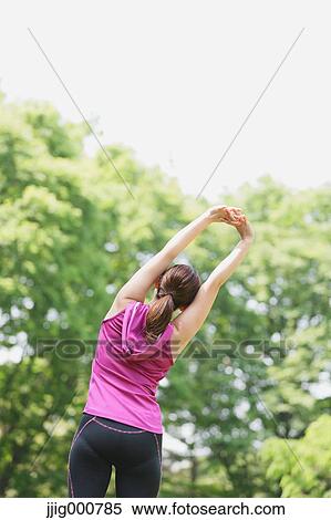 Stock Photography - Young Japanese girl stretching in the park. Fotosearch