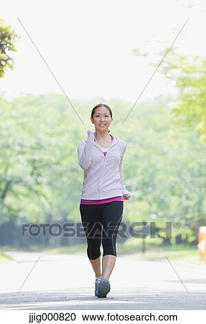 Young Japanese girl walking in the park View Large Photo Image Stock Image - Young Japanese girl walking in the park. Fotosearch