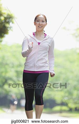 Stock Image - Young Japanese girl walking in the park. Fotosearch