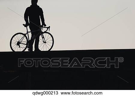 Stock Image - Young Japanese girl with racing bike at sunset. Fotosearch