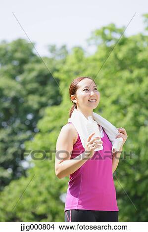 Young Japanese girl with water bottle after training in the park View Large Photo Image Picture - Young Japanese girl with water bottle after training in the park. Fotosearch