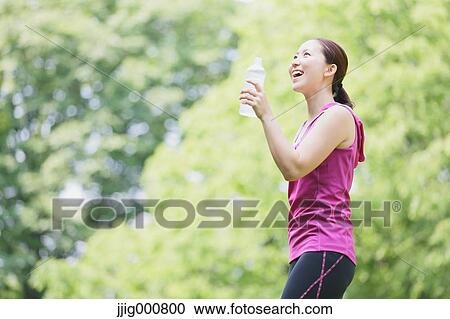 Young Japanese girl with water bottle after training in the park View Large Photo Image Stock Image - Young Japanese girl with water bottle after training in the park. Fotosearch
