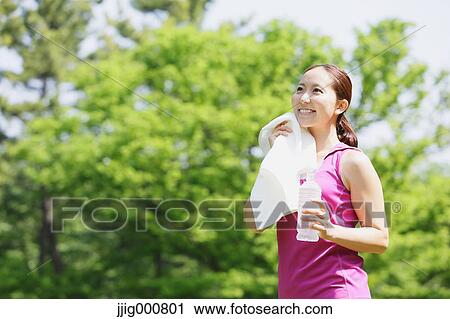 Young Japanese girl with water bottle after training in the park View Large Photo Image Stock Image - Young Japanese girl with water bottle after training in the park. Fotosearch