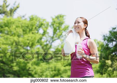 Young Japanese girl with water bottle after training in the park View Large Photo Image Stock Image - Young Japanese girl with water bottle after training in the park. Fotosearch
