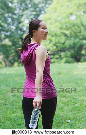 Young Japanese girl with water bottle after training in the park View Large Photo Image Stock Image - Young Japanese girl with water bottle after training in the park. Fotosearch
