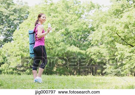 Young Japanese girl with water bottle after training in the park View Large Photo Image Stock Photo - Young Japanese girl with water bottle after training in the park. Fotosearch
