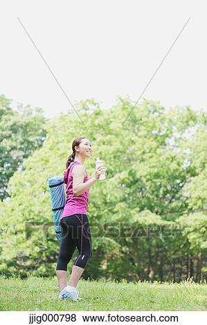 Young Japanese girl with water bottle after training in the park View Large Photo Image Stock Photo - Young Japanese girl with water bottle after training in the park. Fotosearch