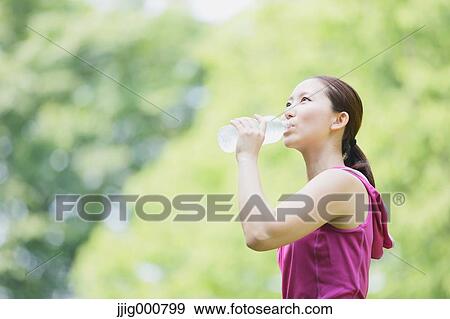 Young Japanese girl with water bottle after training in the park View Large Photo Image Stock Photo - Young Japanese girl with water bottle after training in the park. Fotosearch