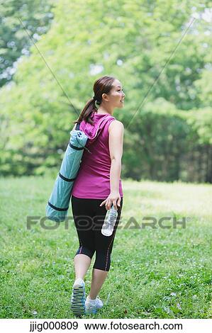 Young Japanese girl with water bottle after training in the park View Large Photo Image Stock Photo - Young Japanese girl with water bottle after training in the park. Fotosearch