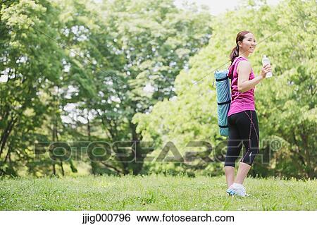 Young Japanese girl with water bottle after training in the park View Large Photo Image Stock Photograph - Young Japanese girl with water bottle after training in the park. Fotosearch
