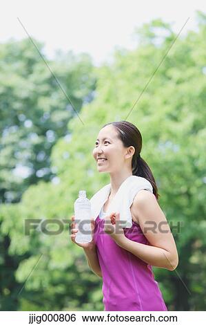 Young Japanese girl with water bottle after training in the park View Large Photo Image Stock Photograph - Young Japanese girl with water bottle after training in the park. Fotosearch