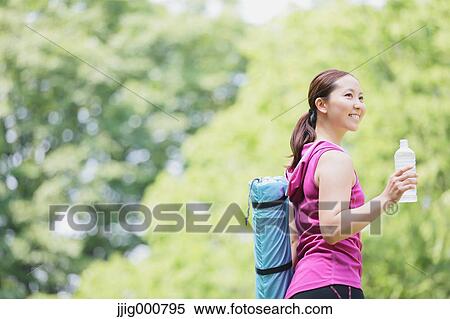 Young Japanese girl with water bottle after training in the park View Large Photo Image Stock Photography - Young Japanese girl with water bottle after training in the park. Fotosearch