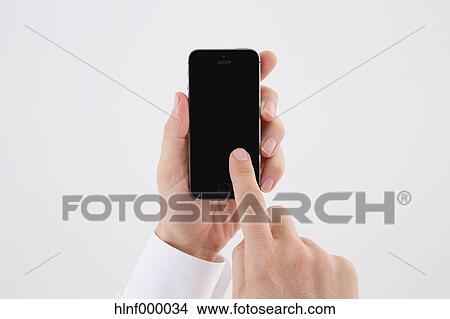 Mid adult man holding smartphone View Large Photo Image Picture - Mid adult man holding smartphone. Fotosearch