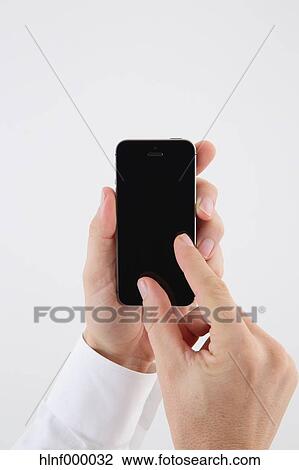 Mid adult man holding smartphone View Large Photo Image Stock Image - Mid adult man holding smartphone. Fotosearch