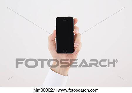 Mid adult man holding smartphone View Large Photo Image Stock Photo - Mid adult man holding smartphone. Fotosearch
