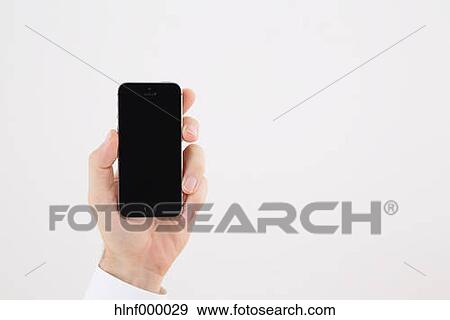 Mid adult man holding smartphone View Large Photo Image Stock Photo - Mid adult man holding smartphone. Fotosearch