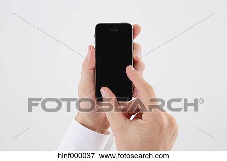 Stock Photo - Mid adult man holding smartphone. Fotosearch
