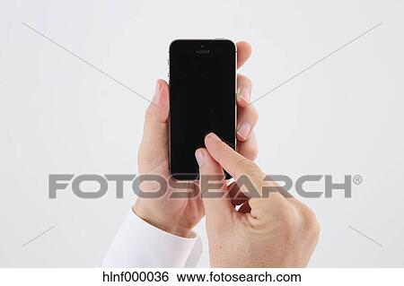 Mid adult man holding smartphone View Large Photo Image Stock Photograph - Mid adult man holding smartphone. Fotosearch
