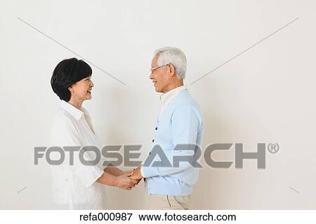 Stock Photo - Senior adult Japanese couple against white wall. Fotosearch
