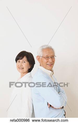 Stock Photograph - Senior adult Japanese couple against white wall. Fotosearch