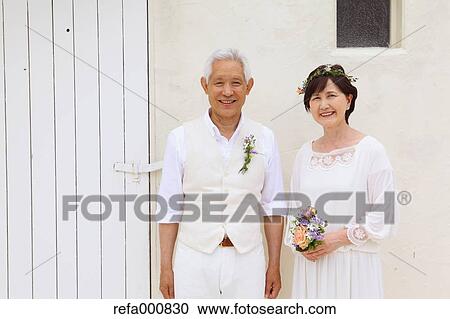Stock Image - Senior adult Japanese couple celebrating. Fotosearch