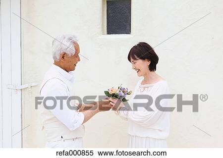 Stock Photography - Senior adult Japanese couple celebrating. Fotosearch