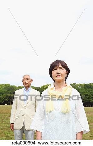 Picture - Senior adult Japanese couple in a park. Fotosearch