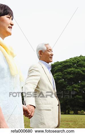 Stock Image - Senior adult Japanese couple in a park. Fotosearch