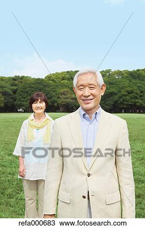 Stock Image - Senior adult Japanese couple in a park. Fotosearch
