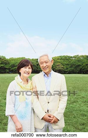 Stock Image - Senior adult Japanese couple in a park. Fotosearch