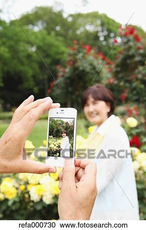 Stock Image - Senior adult Japanese couple in a park. Fotosearch