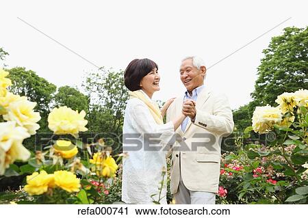 Stock Image - Senior adult Japanese couple in a park. Fotosearch