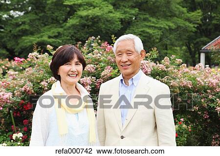 Stock Image - Senior adult Japanese couple in a park. Fotosearch