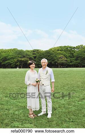 Stock Image - Senior adult Japanese couple in a park. Fotosearch