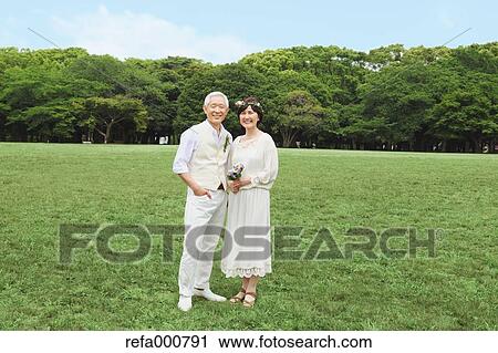 Stock Image - Senior adult Japanese couple in a park. Fotosearch