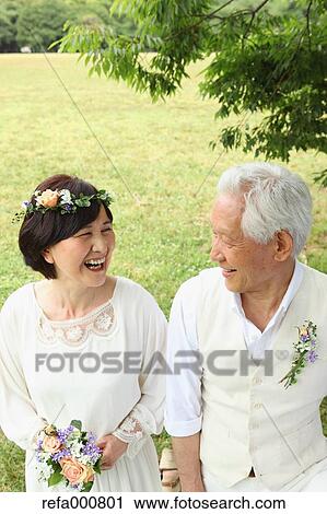Stock Image - Senior adult Japanese couple in a park. Fotosearch