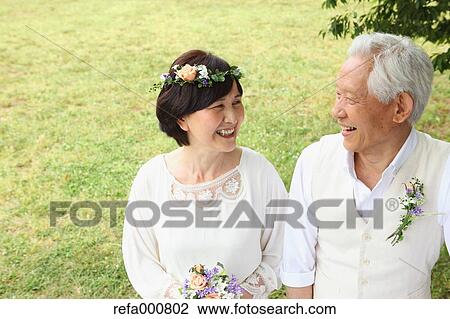Stock Image - Senior adult Japanese couple in a park. Fotosearch