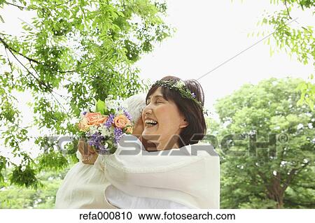 Stock Image - Senior adult Japanese couple in a park. Fotosearch