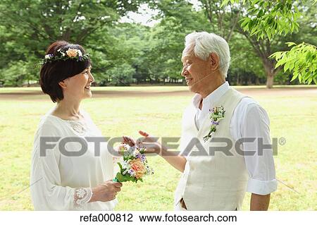 Stock Image - Senior adult Japanese couple in a park. Fotosearch