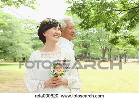 Stock Image - Senior adult Japanese couple in a park. Fotosearch