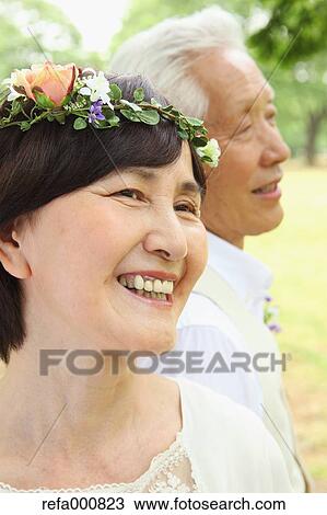 Stock Image - Senior adult Japanese couple in a park. Fotosearch