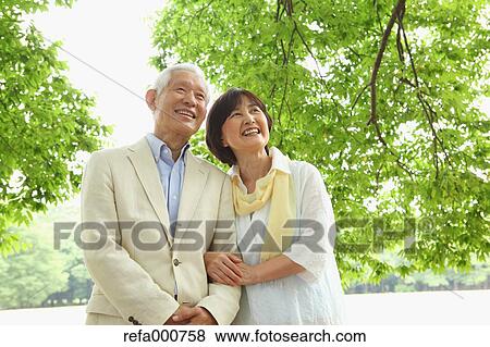 Stock Photo - Senior adult Japanese couple in a park. Fotosearch