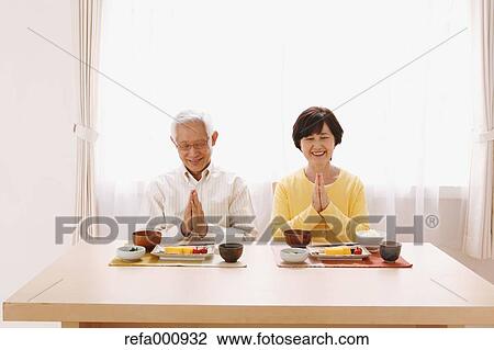 Stock Image - Senior adult Japanese couple in the kitchen. Fotosearch