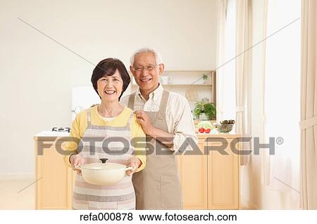 Stock Photo - Senior adult Japanese couple in the kitchen. Fotosearch