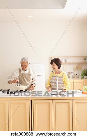 Stock Photo - Senior adult Japanese couple in the kitchen. Fotosearch