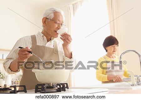 Stock Photo - Senior adult Japanese couple in the kitchen. Fotosearch