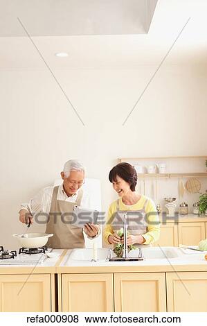 Stock Photo - Senior adult Japanese couple in the kitchen. Fotosearch