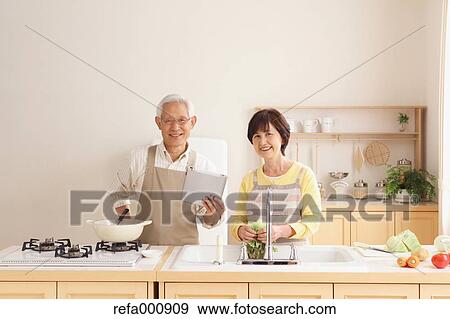 Stock Photo - Senior adult Japanese couple in the kitchen. Fotosearch