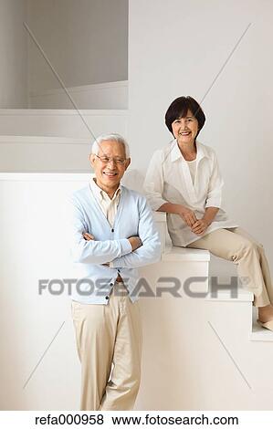 Stock Photo - Senior adult Japanese couple in the living room. Fotosearch